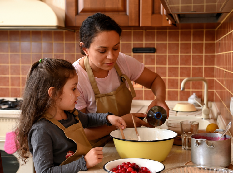 mother and daughter cook together in a kitchen