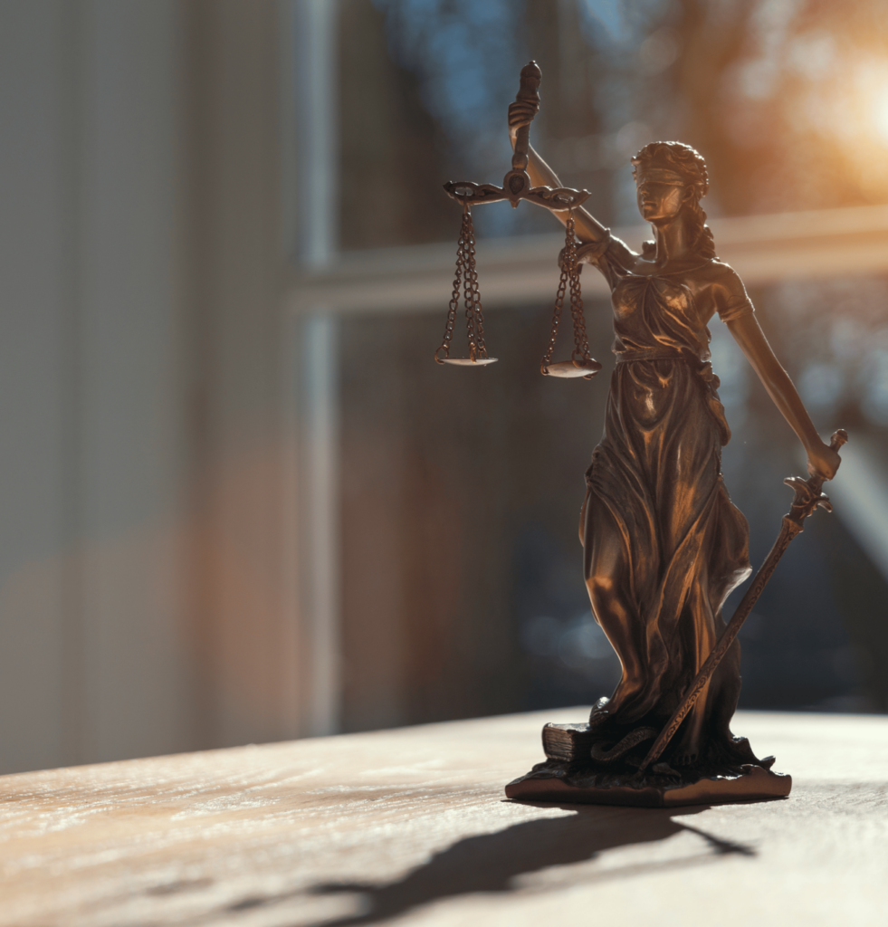 statuette of blondfolded Lady Justice holding scales and a sword